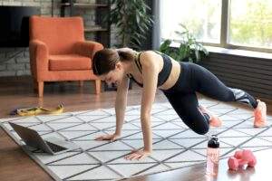 Woman working out at home to online fitness class