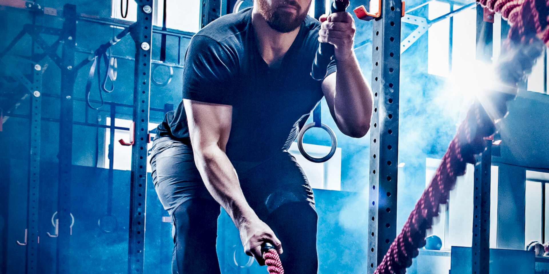 Image of a man in the gym using battle ropes