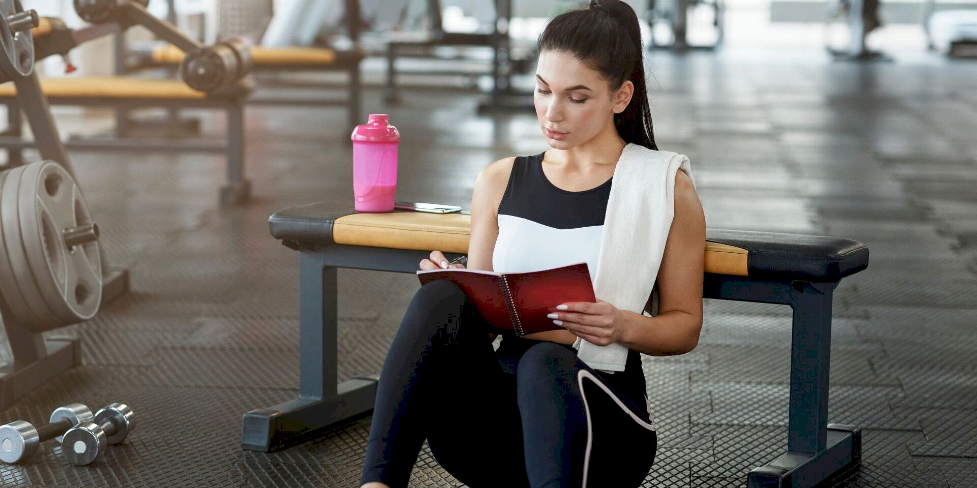 woman writing gym schedule in journal